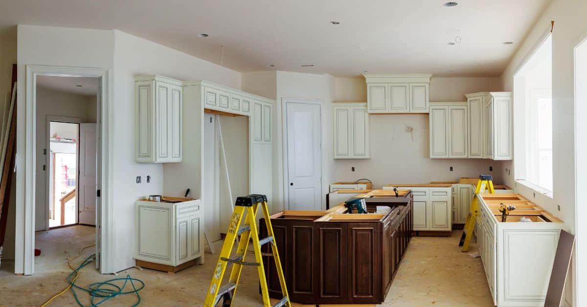 Custom Kitchen Built-Ins Installation Custom white kitchen cabinets being installed during a built-in carpentry project.