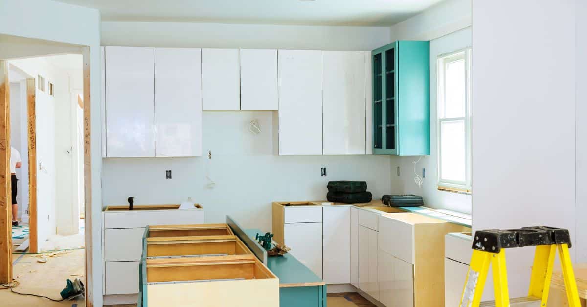 Modern Custom Kitchen Built-In Installation Two-tone modern kitchen with white and teal custom built-in cabinets being installed.