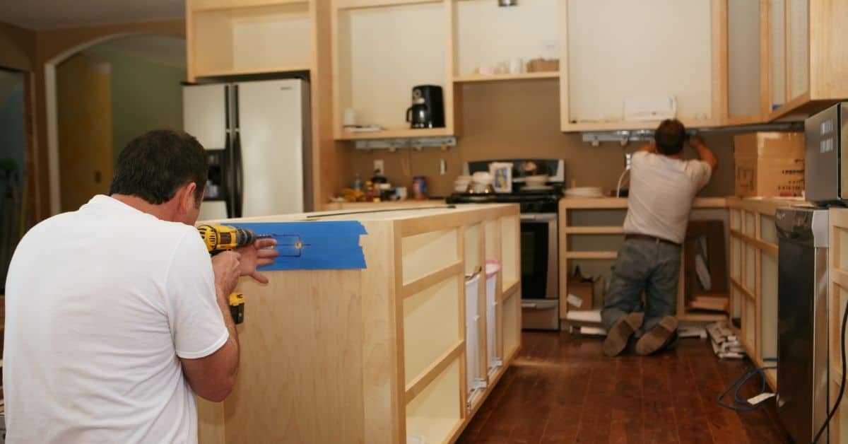Kitchen Island Construction in Remodeling Process Worker drilling and building a kitchen island during a home renovation.