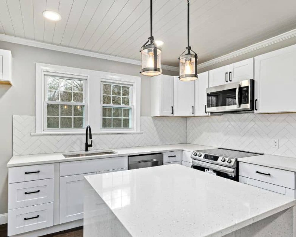 Contemporary kitchen remodeling in Port St. Lucie with white cabinets and modern lighting